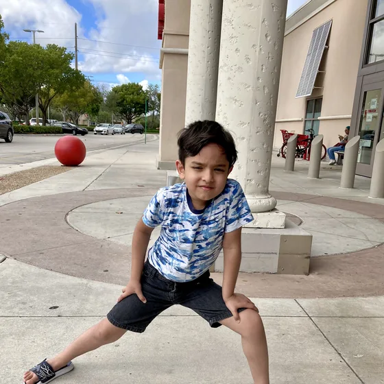 Krishna Behl in a wide squat stance outside, showing off his athletic energy